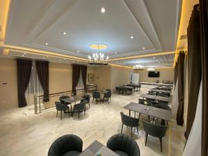 撒马尔罕Turon Lux Hotel的一间在房间内配有桌椅的餐厅