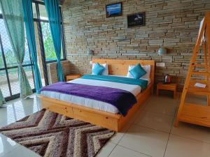 阿尔莫拉Rudra Himalayan Retreat的一间卧室设有木床和砖墙