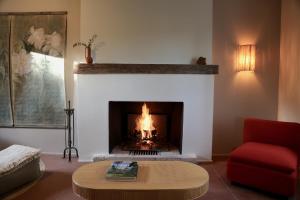 Les Basses MasuresCASAMAAS的客厅设有壁炉和红椅