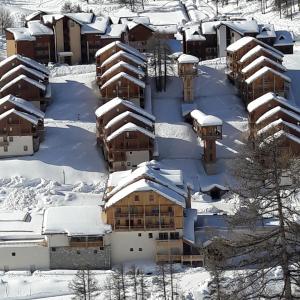 瓦尔residence avec piscine ,chalet des rennes的天空中白雪覆盖的建筑