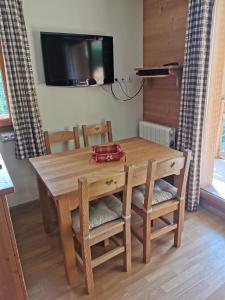 瓦尔residence avec piscine ,chalet des rennes的木制用餐室配有桌椅和电视