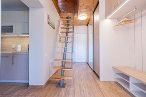 尤尔马拉Schneider hause的厨房设有螺旋楼梯,拥有白色的墙壁和木地板