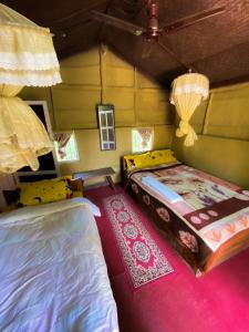 奇旺Nature Safari Camp的一间卧室配有两张床和粉红色的地毯