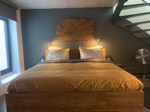 滨海卡特韦克Strand & meer的一间卧室配有一张大床和木制床头板