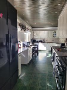 耶姆赛Niittyvilla Apartments的厨房配有白色橱柜和黑色冰箱。