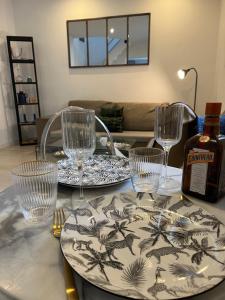 昂热Maison Angers La Madeleine Rooftop的一张带盘子和玻璃杯的桌子和一瓶葡萄酒