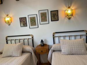 塞古拉 - 德拉谢拉Vivienda Turística Rural Casa Irene的一间卧室配有两张床,墙上有两盏灯