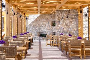 天堂海滩Tropicana Hotel , Suites & Villas Mykonos的亭子里的一排桌椅