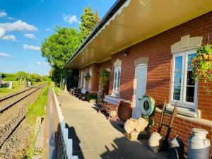 赫里福德The Booking Office, Stoke Edith Station的砖砌建筑旁的火车站