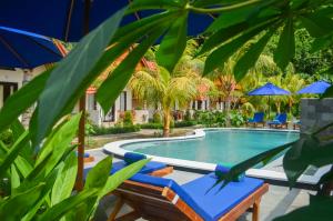 珀尼达岛Penida Bay Village的一个带躺椅和遮阳伞的游泳池