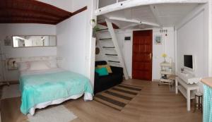 阿鲁卡斯Loft PapaPepe的一间卧室配有一张床、一张书桌和一个楼梯