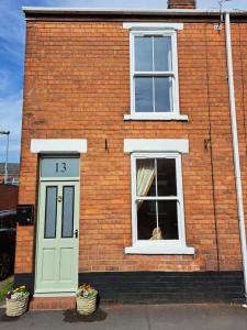 贝弗利Character Beverley Town House的一只狗,看着砖砌的窗户