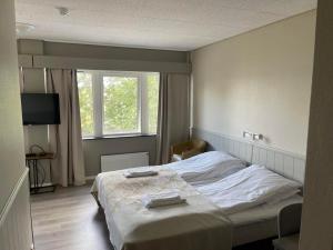 NordstraumenSørreisa Hotell的一间卧室配有一张床和一台电视