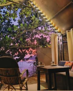 帕特南Nada Brahma Patnem Beach的一间设有桌子的房间和一棵带灯的树