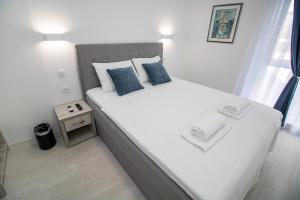 莫斯塔尔Villa Sonata的卧室配有带蓝色枕头的大型白色床