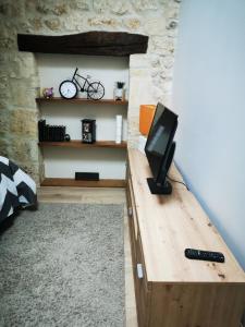 利布尔讷APPARTEMENT COSY LIBOURNE的客房设有木桌和电视。