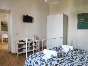 贝内文托Appartamento La Rampa的卧室配有一张床,墙上配有电视。