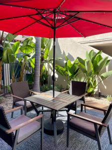圣巴巴拉Beachside Inn的野餐桌和带红伞的椅子