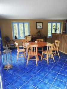 PionnatChambre d'hôte Moulin du Breuil.的蓝色瓷砖地板上的带桌椅的用餐室