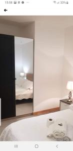 伦敦Jadwin Beautiful Room Share toilet 2 people的卧室配有镜子、一张床和一盏灯