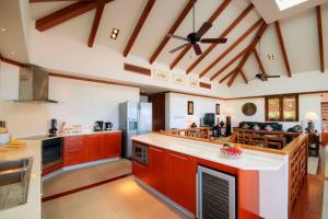芭东海滩Patong Seaview Luxury Villa Penda的一个带木制橱柜和天花板的大厨房