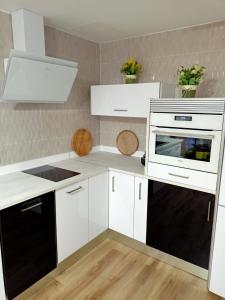 埃勒凡达尔Ángeles home的厨房配有白色橱柜和黑色家电