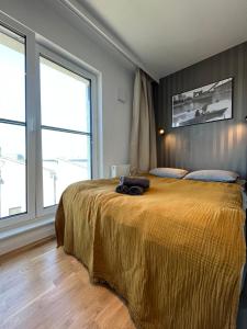 弗罗茨瓦夫Halo Apartments的一间卧室配有一张带黄色床罩的大床
