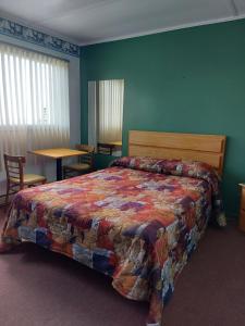 CloridormeMotel du Cap St-Yvon的卧室配有1张床、1张桌子和1把椅子