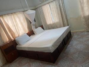 Bakau世界大同旅馆的窗户客房内的小床