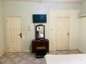 Bakau世界大同旅馆的一间卧室配有一张床、镜子和电视