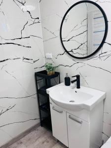 沃尔贾利Projekt Warchały的浴室设有白色水槽和镜子