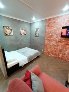 彼得罗巴甫洛夫斯克Квартира бизнес -класса в ста метрах от городского парка的一间卧室设有一张床和砖墙