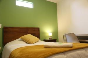 安托法加斯塔Aparthotel Don Alonso的一间卧室配有一张带枕头和椅子的床