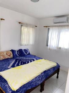 AmdalaiSwiss Garden House in Kerr Sering With Full Private Compound的一间卧室配有一张带蓝色床单和窗户的床。