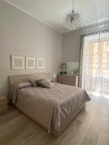 那不勒斯Dea Suite的白色卧室配有一张床和一个吊灯