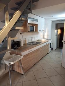 豪伊杜索博斯洛Marcell Apartman的一个带木制橱柜和水槽的厨房