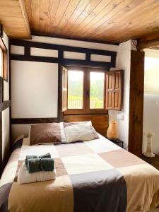 CambreCasita rústica的一间带一张大床的卧室,位于一个拥有木制天花板的房间