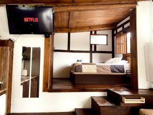 CambreCasita rústica的卧室配有一张床,墙上配有电视。