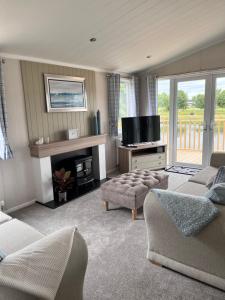 West BradfordEdmonton Lodge的客厅配有两张沙发和一台电视