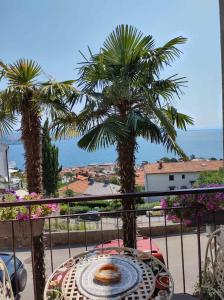 奥帕提亚Alba Opatija的棕榈树和海洋阳台的桌子