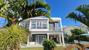 RéunionLovely brand new luxury 2-bedroom apartment in Vacoas, Mauritius的前面有棕榈树的白色房子