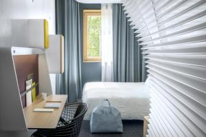 格勒诺布尔格勒诺布尔赫哲花园奥科酒店的酒店客房配有一张床和一张带椅子的书桌