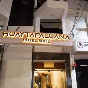 万卡约Hotel Huaytapallana suites的大楼前的酒店标志