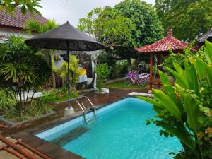 蓝梦岛Pantai Bungalow Lembongan Island的一座房子旁带遮阳伞的游泳池