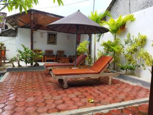 蓝梦岛Pantai Bungalow Lembongan Island的一个带椅子和遮阳伞的庭院