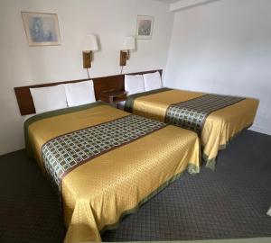 利柏提Kansan Motel的两张睡床彼此相邻,位于一个房间里