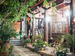 丽江丽江古城坨坨客栈的建筑里带有盆栽和楼梯的走廊