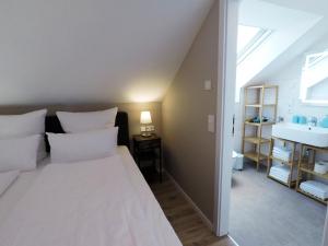 富尔达-Neubau- 30qm Dach-Apartment的卧室配有白色大床和水槽