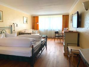 奥格斯堡Ringhotel Alpenhof - Patchworkhotel的酒店客房设有两张床和一张桌子。