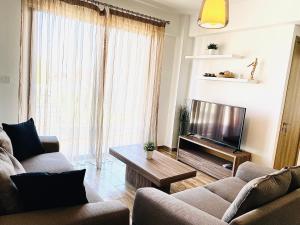 拉纳卡BALI SUITES 202的客厅配有两张沙发和一台电视